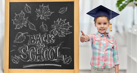 Image showing student girl in bachelor hat showing thumbs up