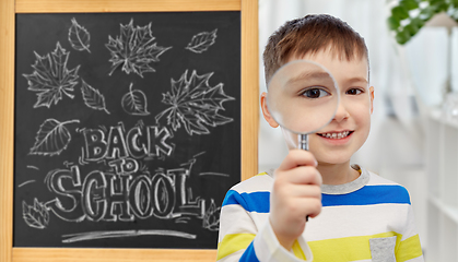 Image showing student boy looking through magnifying glass