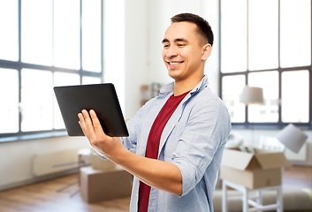 Image showing happy young man with tablet computer over new home