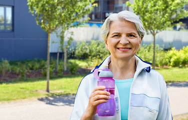 Image showing sporty senior woman with bottle of water in city