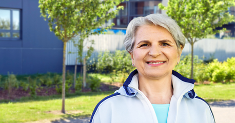 Image showing smiling sporty senior woman in city