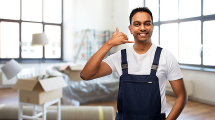 Image showing happy worker making phone call gesture at new home