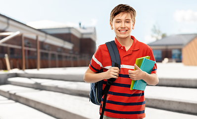 Image showing smiling student boy with backpack and books