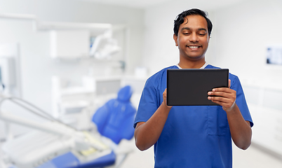 Image showing smiling doctor using tablet pc at dental office