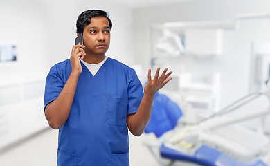 Image showing indian doctor calling on phone at dental office