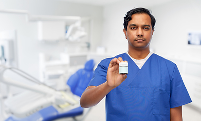 Image showing indian doctor holding medicine at dental office