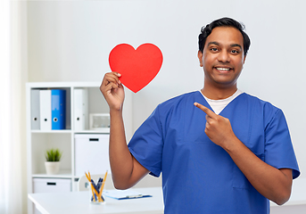 Image showing smiling male doctor with red heart on clipboard