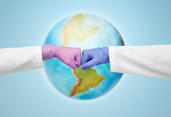 Image showing hands of doctors in gloves make fist bump gesture