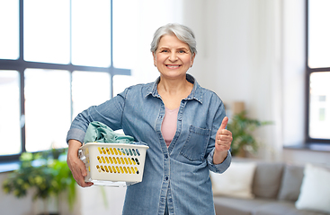 Image showing smiling senior woman with laundry basket