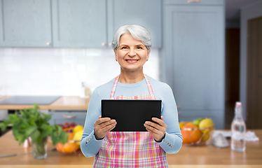 Image showing smiling senior woman with tablet pc at kitchen