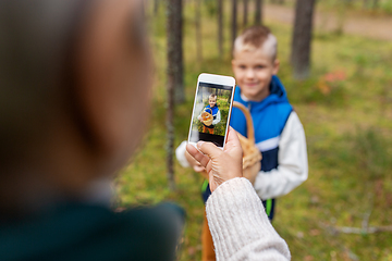 Image showing grandmother photographing grandson with mushrooms