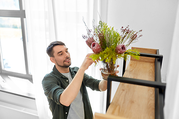 Image showing man decorating home with flowers in vase