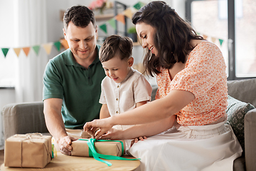 Image showing happy family opening birthday presents at home