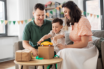 Image showing happy family opening birthday presents at home