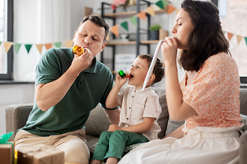 Image showing happy family with gifts and party blowers at home