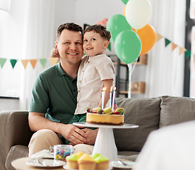 Image showing happy father and son with birthday cake at home