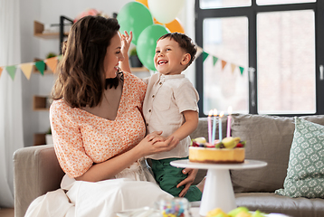 Image showing happy mother and son with birthday cake at home