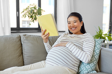 Image showing happy pregnant woman reading book at home