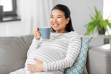 Image showing happy pregnant woman drinking tea at home