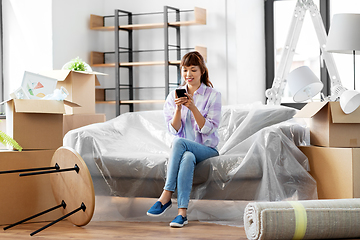 Image showing asian woman with smartphone moving into new home