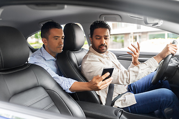 Image showing male passenger showing smartphone to car driver