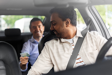 Image showing smiling passenger giving money to taxi car driver