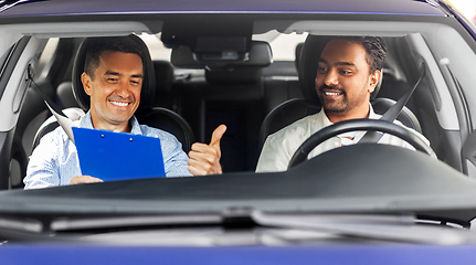 Image showing smiling car driving school instructor and driver