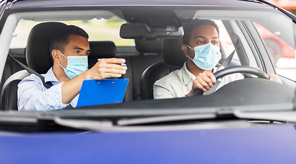 Image showing car driving school instructor and driver in mask