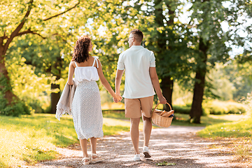 Image showing happy couple with picnic basket at summer park