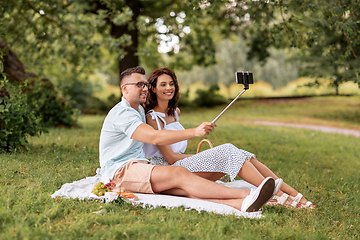 Image showing happy couple taking selfie at picnic in park