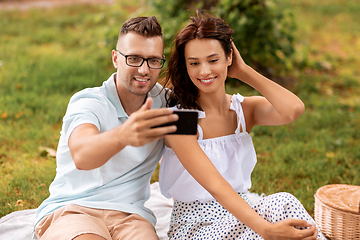 Image showing happy couple taking selfie at picnic in park