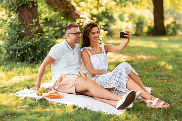 Image showing happy couple taking selfie at picnic in park