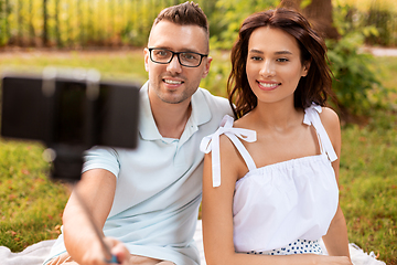 Image showing happy couple taking selfie at picnic in park