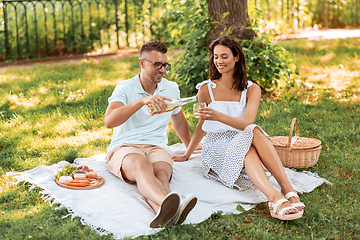 Image showing happy couple with wine having picnic at park