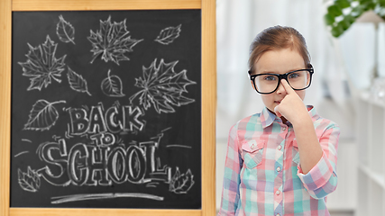 Image showing little student girl in glasses over chalkboard