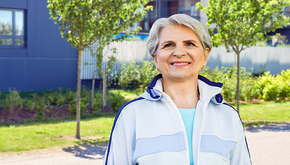 Image showing smiling sporty senior woman in city