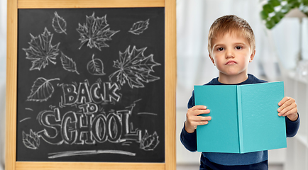 Image showing little displeased student boy with book