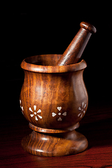 Image showing Wooden mortar and pestle on dark