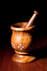 Image showing Wooden mortar and pestle on dark