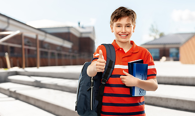 Image showing student boy with bag and books showing thumbs up