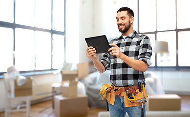 Image showing happy builder with tablet pc and tools at home