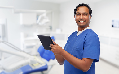 Image showing smiling doctor using tablet pc at dental office