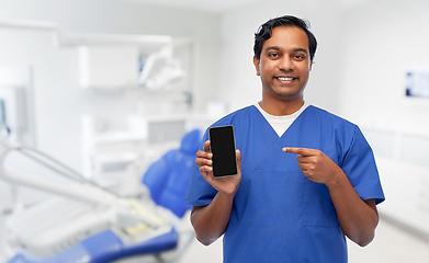 Image showing smiling doctor with smartphone at dental office