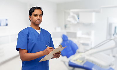 Image showing male doctor with clipboard at dental office