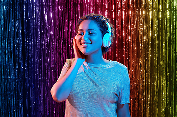 Image showing woman in headphones listening to music and dancing