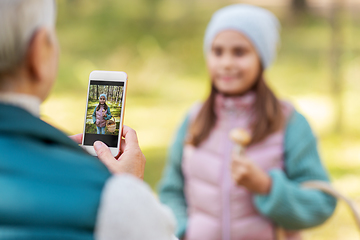 Image showing grandma photographing granddaughter with mushrooms