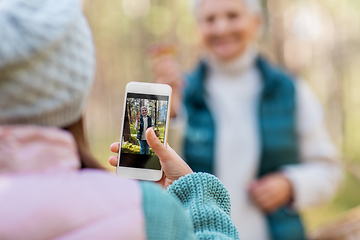 Image showing granddaughter photographing grandma with mushrooms