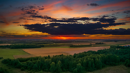 Image showing Colorful sunset over forest and fields aerial