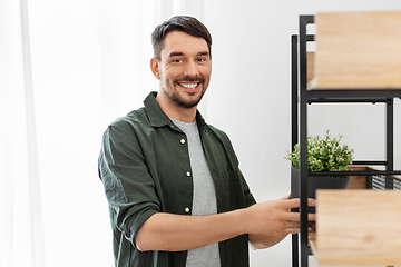 Image showing man decorating home with flower or houseplant