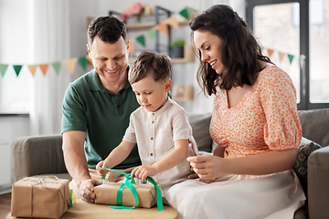 Image showing happy family opening birthday presents at home